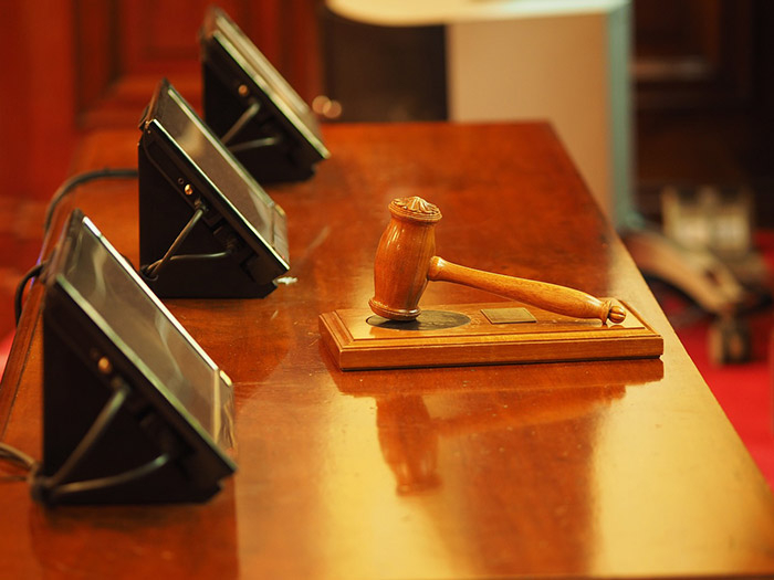 A picture of a judge's gavel resting on a courtroom table
