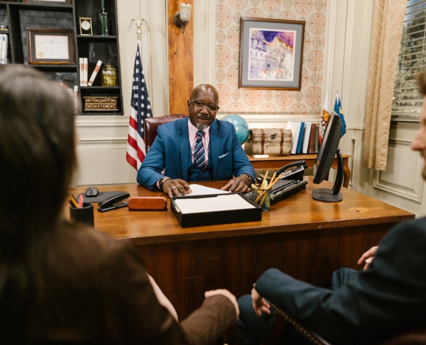 A lawyer consulting with two clients in a criminal defense case